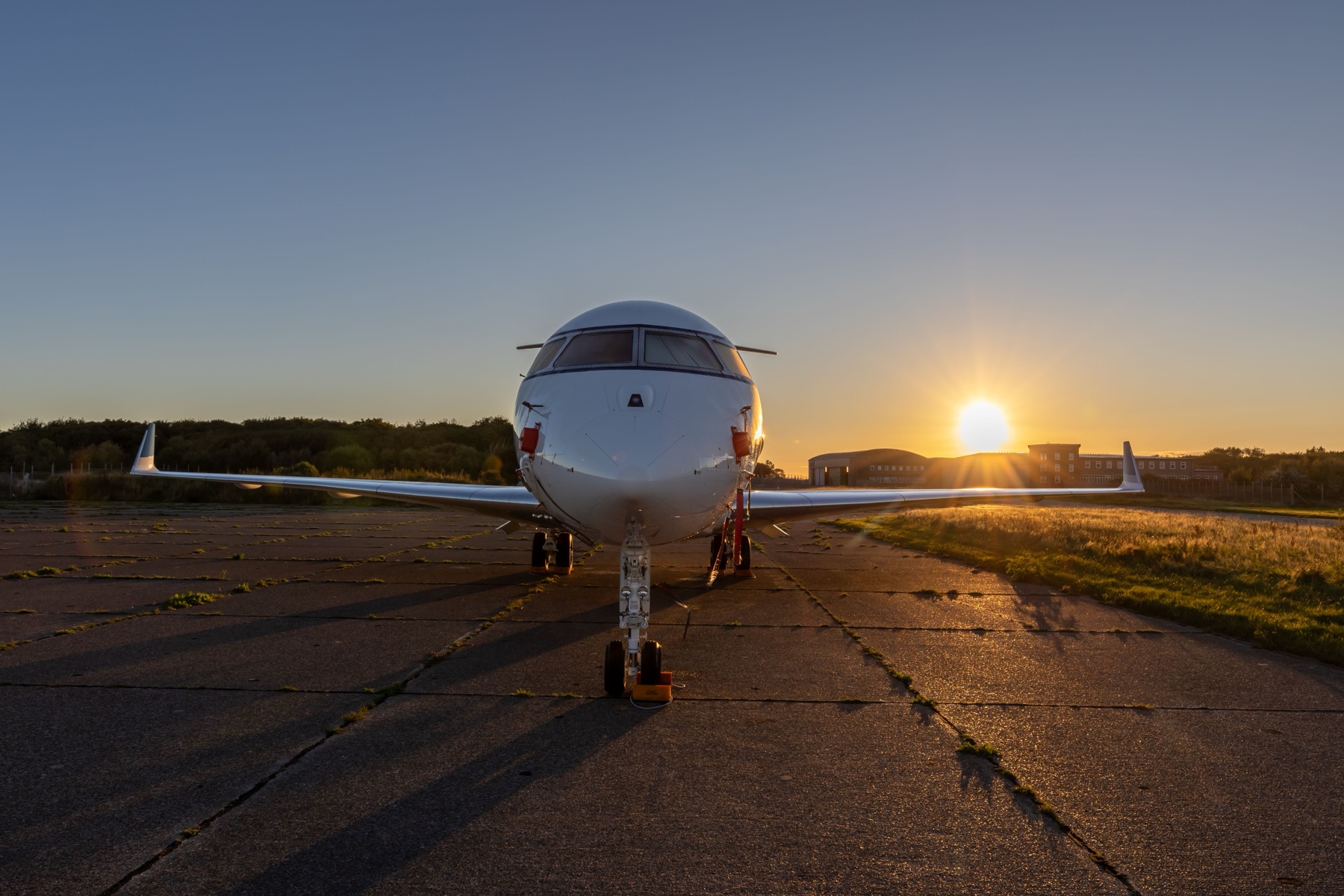 Private jet waiting on a runway at sunset